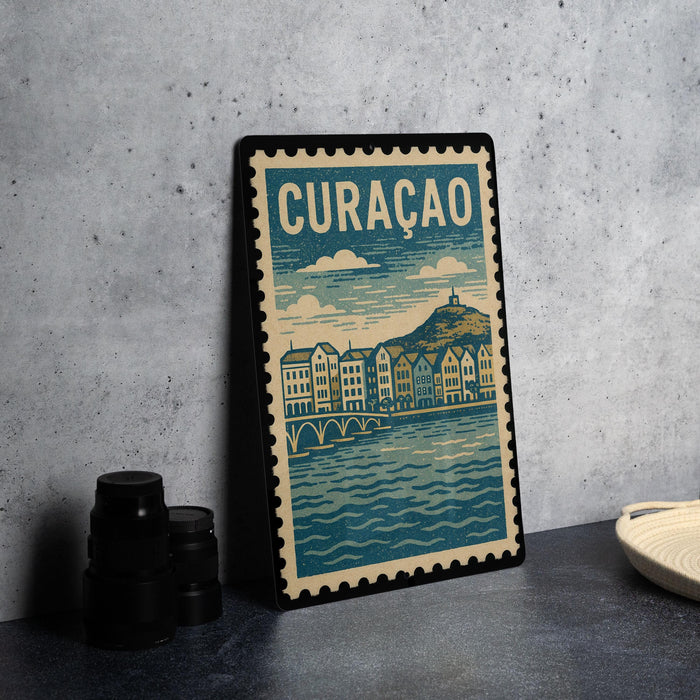 A framed poster of a cityscape with a river and buildings, featuring the word "CURACÊO" prominently displayed.