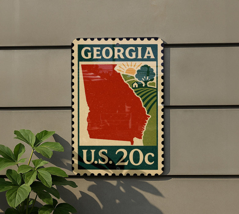 A U.S. postage stamp from Georgia, featuring a red state outline and a green field with a tree, mounted on a wall.
