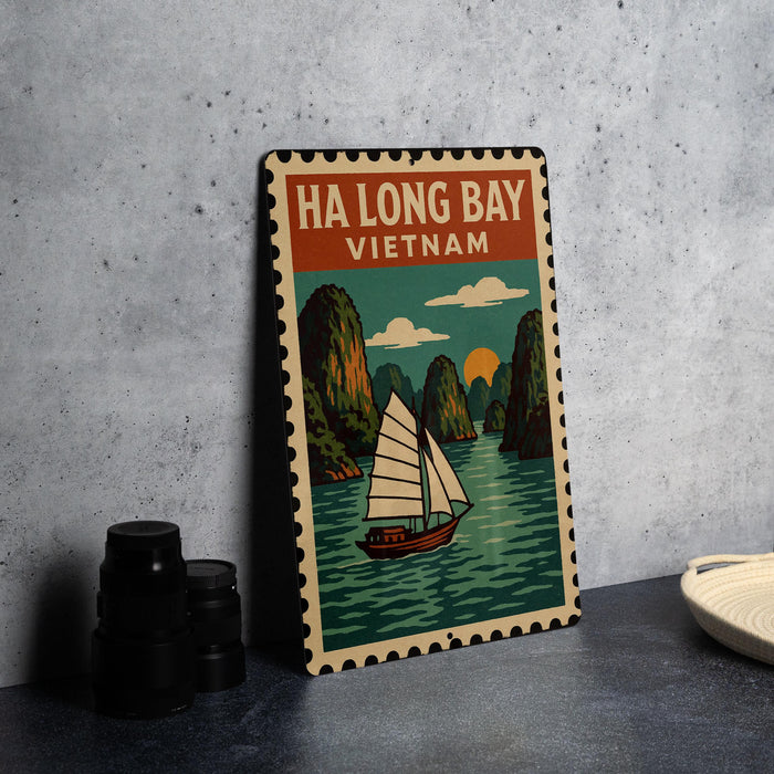A vintage-style metal sign with a sailboat illustration and the text "HA LONG BAY VIETNAM" is displayed on a gray wall.