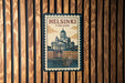 A vintage-style postage stamp depicting the Helsinki Cathedral in Finland, with the text "HELSINKI FINLAND" prominently displayed.