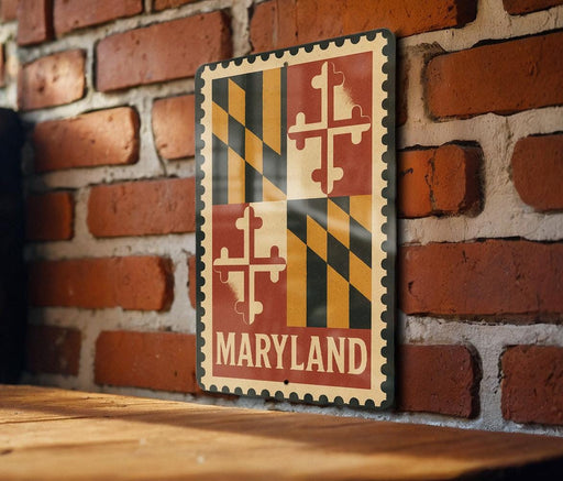 A metal sign with the word "MARYLAND" displayed on it, mounted on a brick wall.