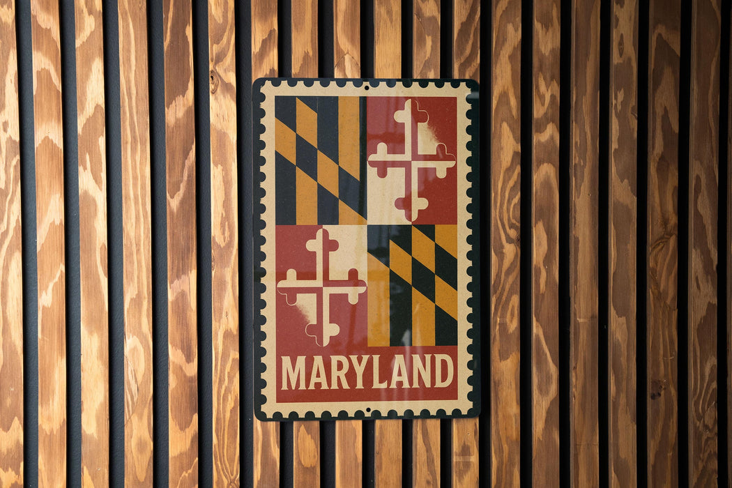 A metal sign with the word "MARYLAND" printed on it, mounted on a wooden wall.