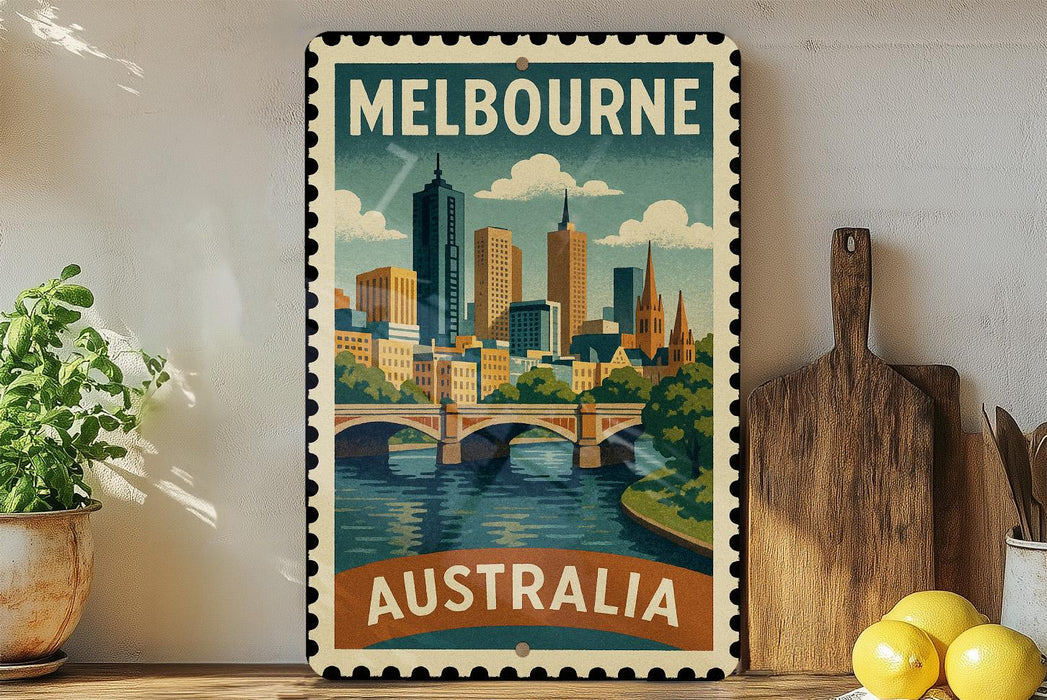 A vintage-style metal stamp depicting the Melbourne skyline, with a bridge and water in the foreground, is displayed on a shelf next to a wooden cutting board and some lemons.