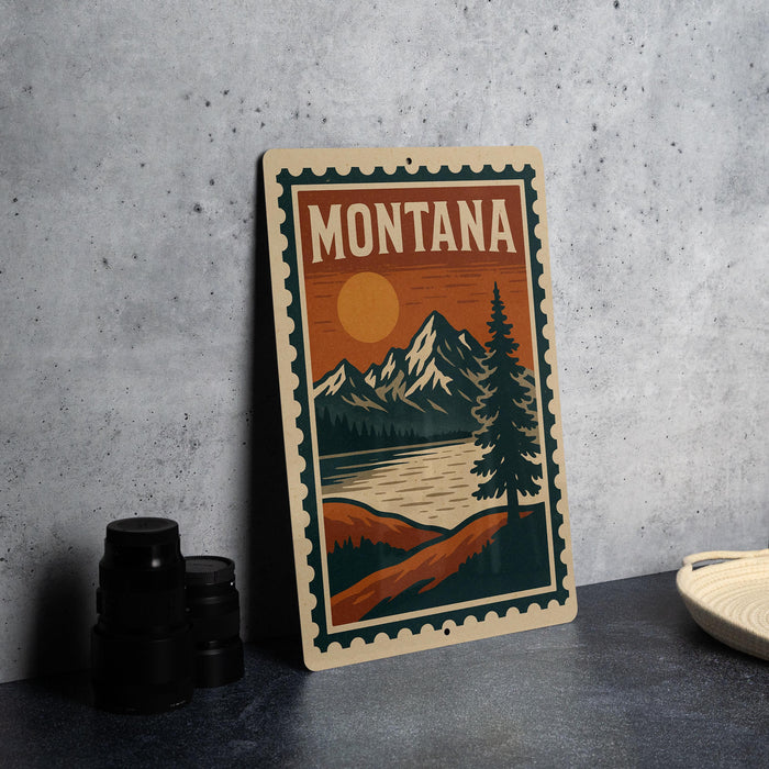 A framed poster of Montana scenery, including mountains, a lake, and a pine tree, is displayed on a countertop next to some black camera lenses.
