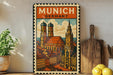 a vintage-style poster of Munich, Germany, with a colorful illustration of the city's landmarks and architecture. The poster is displayed on a wall, with a wooden cutting board and a potted plant to the left, and a bowl of lemons to the right.