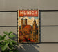A vintage-style poster of the city of Munich, Germany, featuring the city's iconic landmarks and architecture, displayed on a wall.