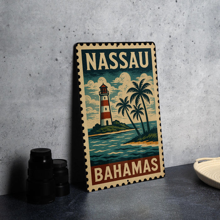 A vintage-style metal sign with a lighthouse and palm trees, depicting the Bahamas, is displayed on a table.