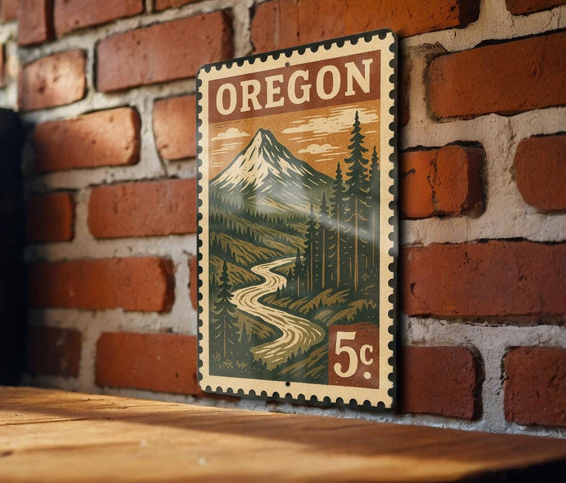 A vintage-style metal sign with the word "OREGON" printed on it, depicting a mountain landscape with a winding river.