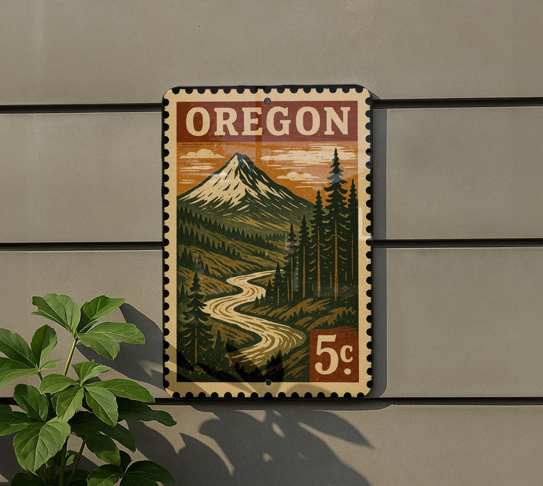 A vintage-style postage stamp depicting a mountain landscape with a winding river, mounted on a wall next to a plant.