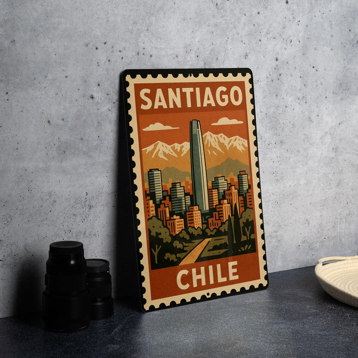 A metal sign with a vintage-style illustration of Santiago, Chile, featuring a tall skyscraper and mountains in the background.
