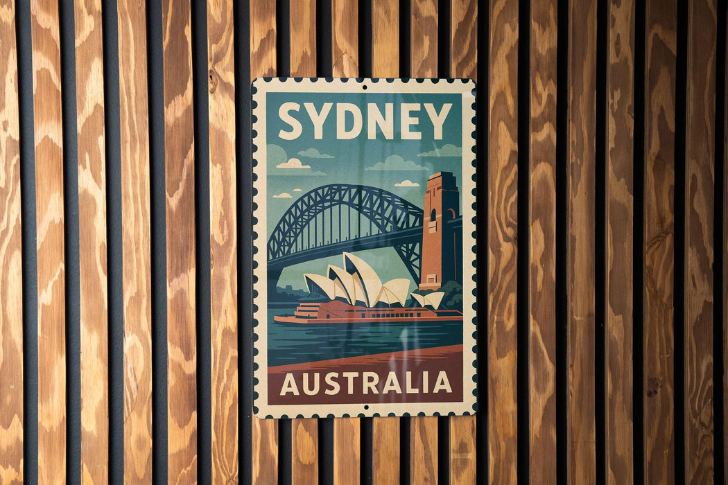 A vintage-style poster of Sydney, Australia, featuring the iconic Sydney Opera House and the Sydney Harbour Bridge, is displayed on a wooden wall.