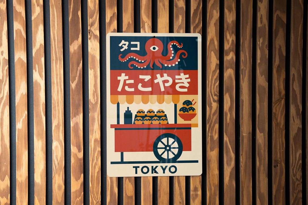 A colorful poster with an illustration of an orange and black octopus, along with Japanese text and a wheeled cart, mounted on a wooden wall.