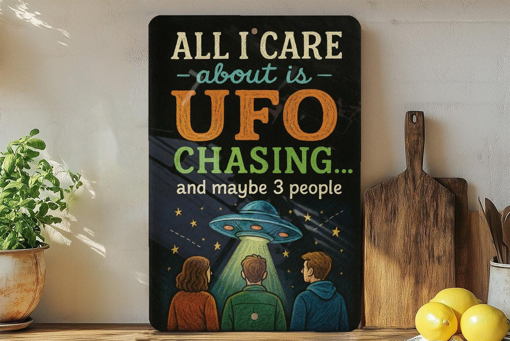 a humorous sign with the text "All I care about is UFO chasing... and maybe 3 people" along with an illustration of three people looking up at a UFO.