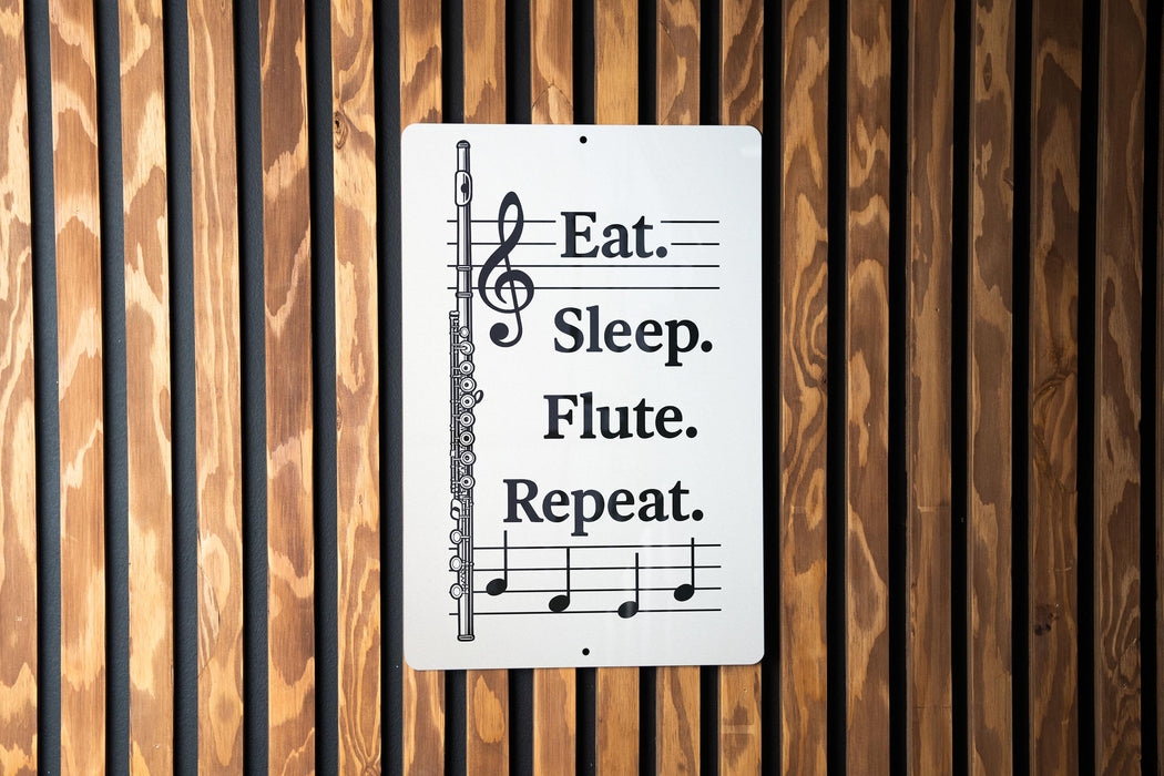 a sign with the text "Eat. Sleep. Flute. Repeat." and a musical note symbol, placed on a wooden wall.