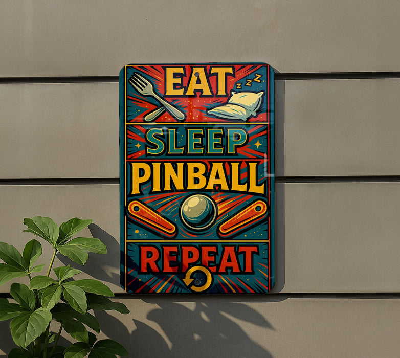 a colorful sign with the text "EAT SLEEP PINBALL REPEAT" displayed on it.