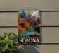 A vintage metal sign with a scenic image of Sedona, a famous rock formation in Arizona, hanging on a wall.