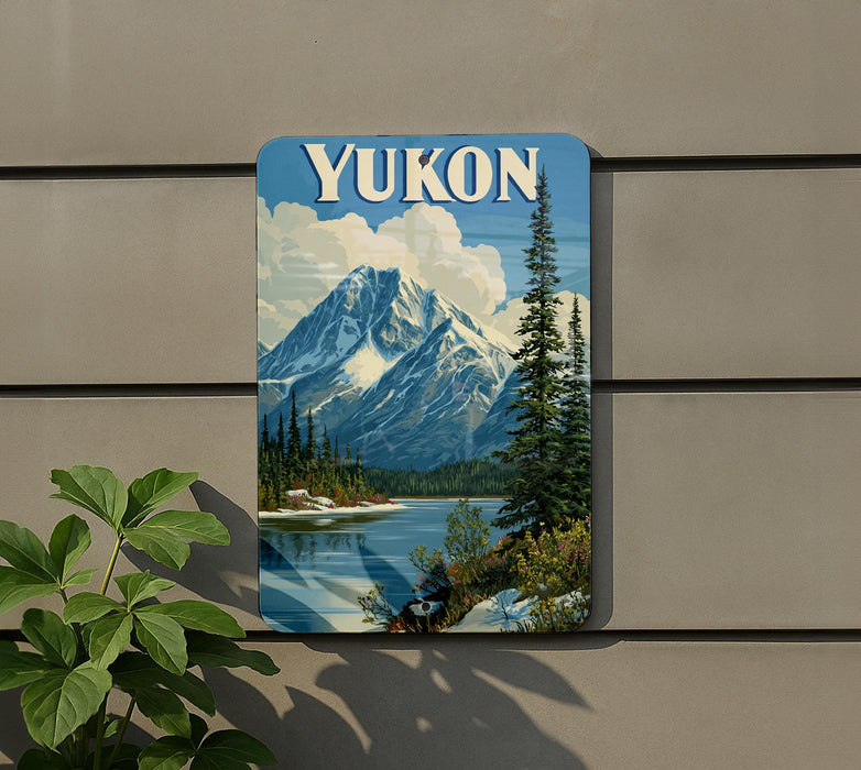 A vintage-style sign with the word "Yukon" prominently displayed, depicting a scenic mountain landscape with a lake and pine trees.