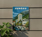 A vintage-style poster of Juneau, the capital city of the state of Montana, USA, featuring a cityscape with buildings, cars, and mountains in the background.
