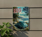 A vintage-style sign with the text "BIG SUR" displayed prominently, featuring a scenic coastal landscape with a car driving along a road.
