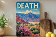 A framed vintage-style poster of Death Valley, a famous desert region in California, is displayed on a wall next to a wooden cutting board and some potted plants.