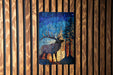 a vibrant stained glass artwork depicting a deer with antlers, set against a backdrop of a forest scene.