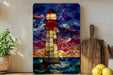 A vibrant stained glass artwork depicting a lighthouse is displayed on a wall, with a wooden cutting board and a potted plant nearby.