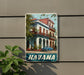 A vintage-style metal sign with a colorful image of a building and a car, mounted on a wall.
