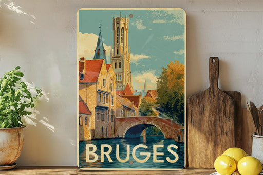 A vintage-style poster of the city of Bruges, Belgium, featuring a church with a bell tower and a bridge over a canal. The poster is displayed on a wall next to a wooden cutting board and some potted plants.