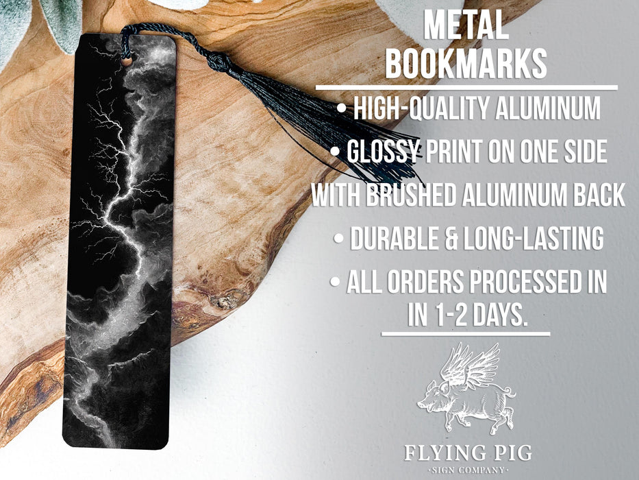 a metal bookmark with a black and white lightning bolt design, placed on a wooden surface.