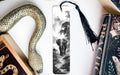 a black and white photograph of an elephant walking through a forest, with a decorative snake and a book titled "Practice" on display.