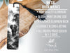 a metal bookmark with a black and white elephant image on it, placed on a wooden surface.