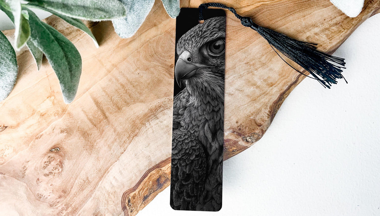 A close-up of a bird's face, possibly a hawk or falcon, is featured prominently on a wooden surface, with a black tassel hanging from the top.