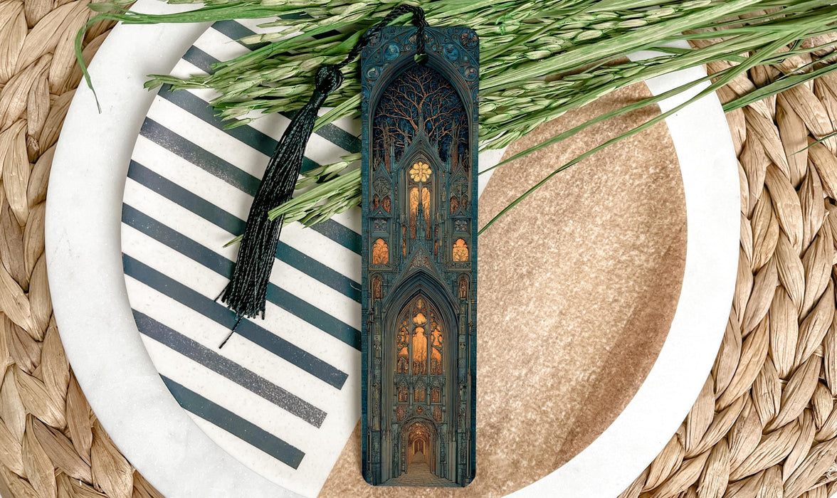 A decorative bookmark with an intricate design, placed on a plate with a striped pattern and a sprig of greenery.