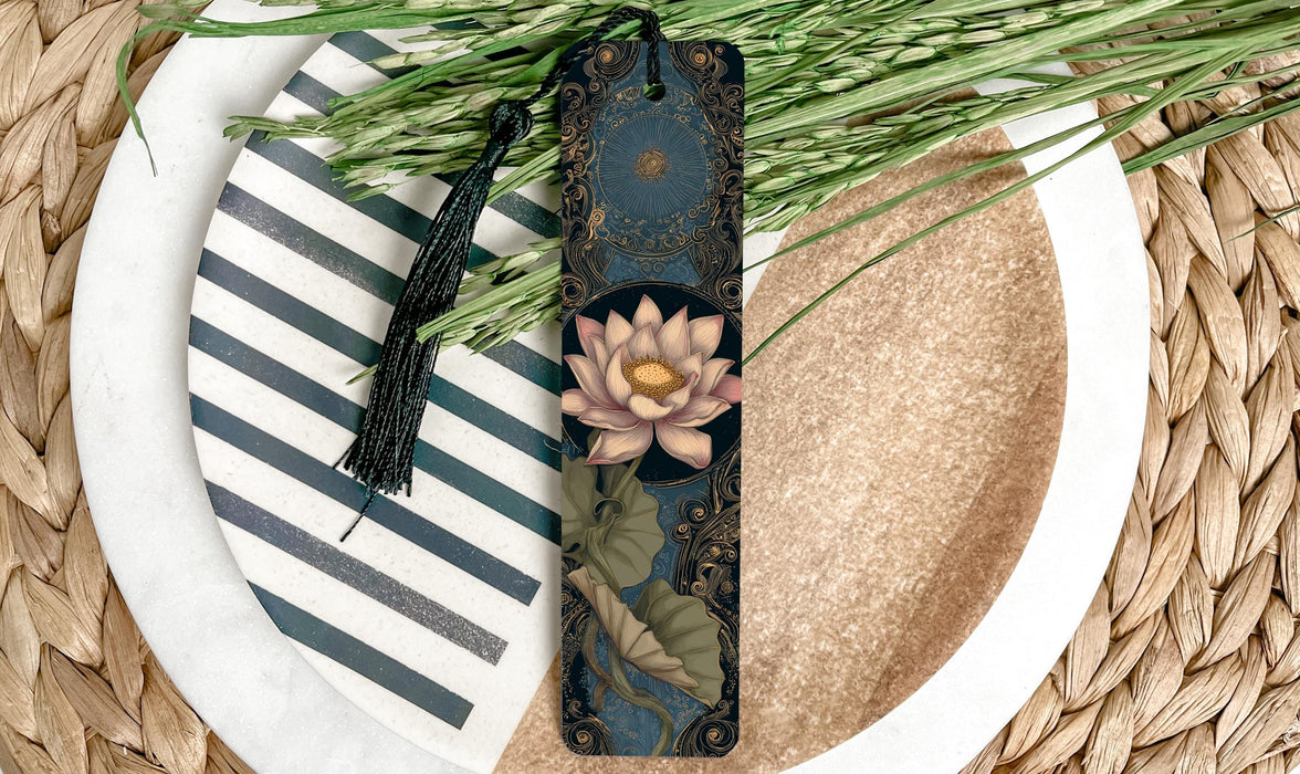 A decorative bookmark with a floral design and a tassel is placed on a plate with a striped pattern, surrounded by green grass.