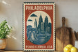 A vintage-style metal sign with a Philadelphia skyline and a bell, placed on a wooden surface next to a wooden cutting board and some lemons.
