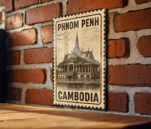 A vintage-style metal sign with a temple illustration and the text "PHNOM PENH" and "CAMBODIA" is displayed on a brick wall.