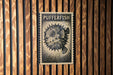 A black and white illustration of a pufferfish is displayed on a wooden wall.