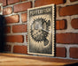 a wooden table with a framed poster of a pufferfish hanging on the wall behind it.