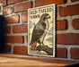 a wooden table with a framed illustration of a red-tailed hawk perched on a branch.
