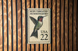 A postage stamp featuring a hummingbird, with the text "Ruby-throated Hummingbird" and the number "22" printed on it.
