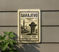 a sign with the text "SARAJEVO" and "BOSNIA AND HERZEGOVINA" printed on it, along with an illustration of a mosque and a fountain.