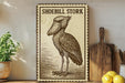a wooden sign with a drawing of a bird, specifically a stork, and the text "Shoebill Stork" written on it. The sign is placed on a shelf next to a wooden cutting board and some lemons.