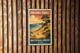 A vintage-style postage stamp featuring a scenic landscape of the Indiana Dunes National Park in the United States.