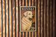 A metal stamp featuring a golden retriever dog on a wooden background.