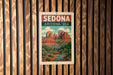 A vintage-style metal sign with the text "SEDONA ARIZONA USA" displayed on it, featuring a scenic illustration of Sedona, Arizona.