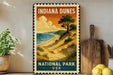 A vintage-style metal sign for Indiana Dunes National Park, featuring a scenic landscape with a beach, mountains, and a tree.