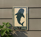 a sign with a picture of a whale shark, mounted on a wall.