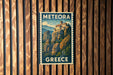 A vintage postage stamp from Greece featuring a mountainous landscape with a castle or building on a cliff.
