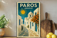 A vintage-style poster of a Greek village, featuring a sun, buildings, and flowers, is displayed on a wall next to a wooden cutting board and a potted plant.