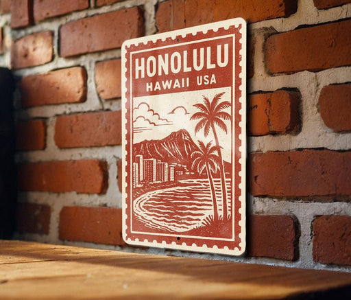 A red and white sign with the text "HONOLULU HAWAII USA" and an illustration of a beach and mountain landscape.